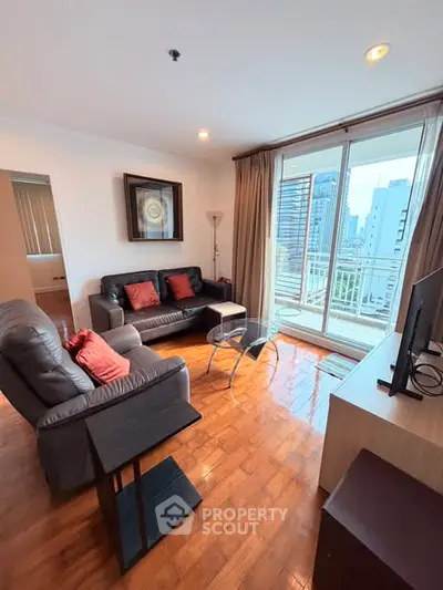 Spacious living room with city view, modern furniture, and large windows for natural light.