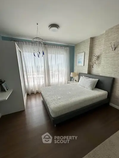 Modern bedroom with large window and stylish decor in a contemporary apartment.