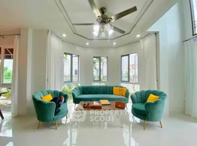 Elegant living room with stylish green sofas and large windows offering natural light.