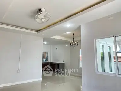 Spacious open-plan living area with modern kitchen and elegant chandelier.