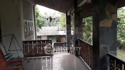 Charming covered patio with decorative railings and lush garden view, perfect for relaxation and outdoor enjoyment.