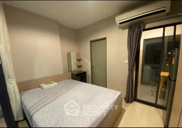 Modern bedroom with air conditioning and balcony access in a stylish apartment.