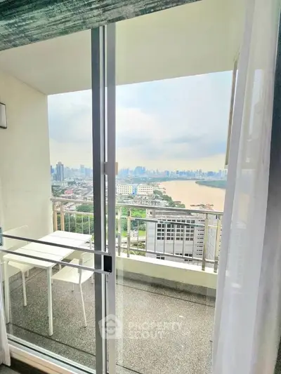 Stunning high-rise balcony view with city skyline and river, perfect for urban living.