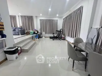 Spacious modern living room with exercise equipment and elegant dining area