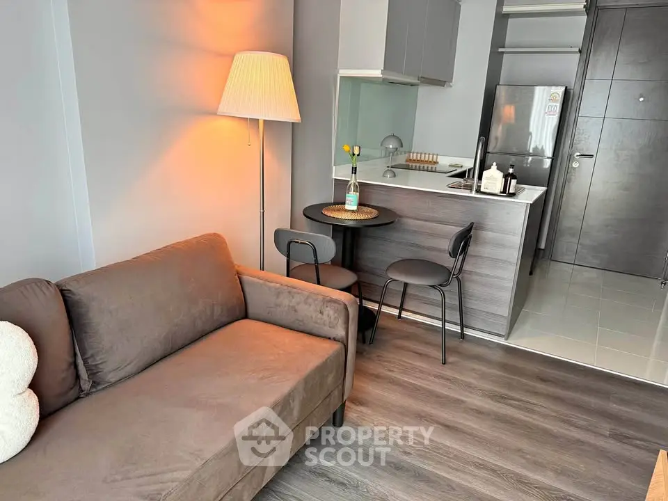 Modern living room with cozy sofa and compact kitchen in stylish apartment