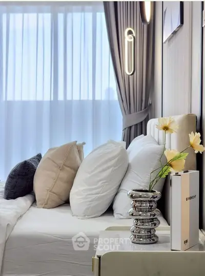 Luxurious bedroom with elegant decor and plush pillows, featuring a modern bedside table and ambient lighting.