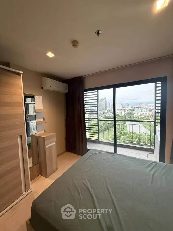 Modern bedroom with large window offering stunning city and river views, featuring sleek furniture and neutral tones.