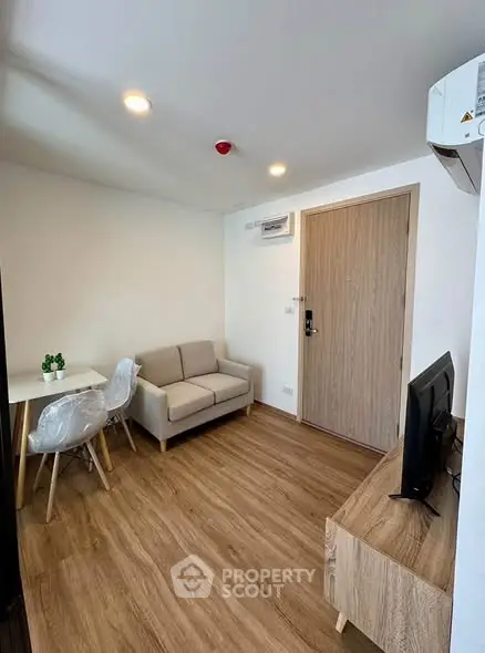 Modern living room with wooden flooring and minimalist furniture in a cozy apartment.