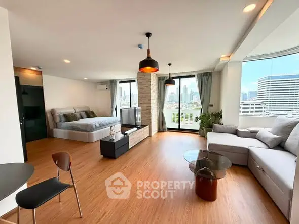Spacious modern living room with city view, featuring stylish furniture and large windows.