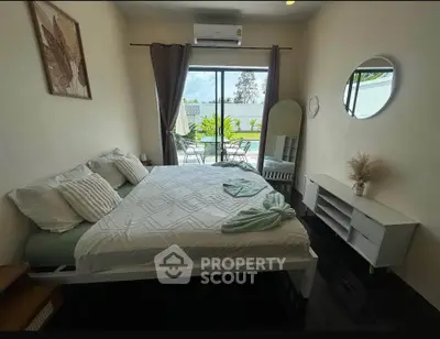 Spacious bedroom with modern decor and balcony access, featuring a large bed and stylish furnishings.
