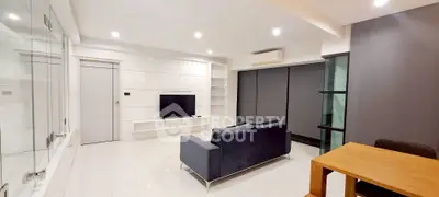 Modern living room with sleek design, featuring a cozy sofa, TV, and stylish shelving in a bright, spacious setting.