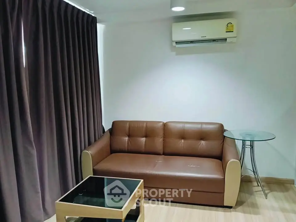 Cozy living room with brown leather sofa and modern glass table, perfect for relaxation.