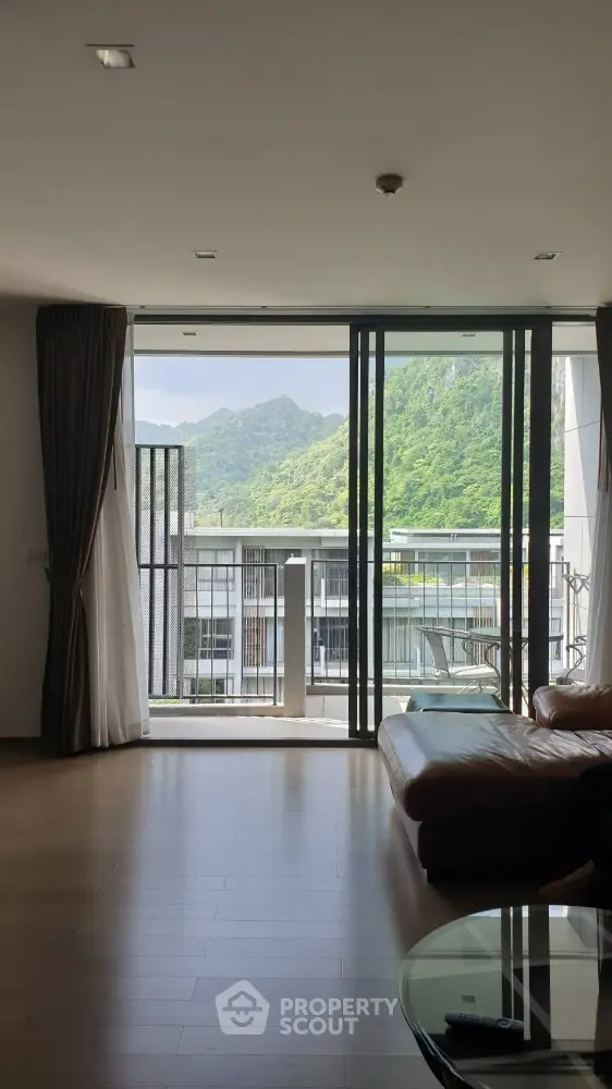 Spacious living room with stunning mountain view and large glass doors.