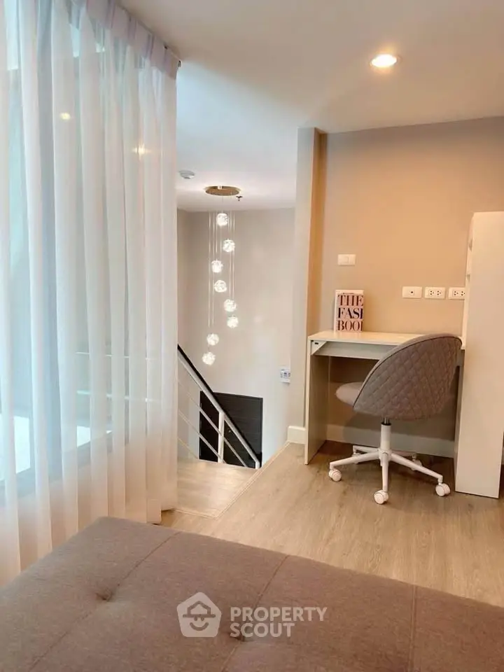 Modern study nook with stylish chair and elegant lighting in a cozy apartment setting.