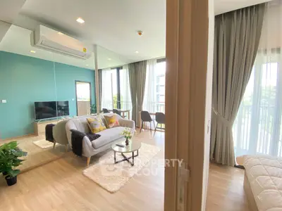 Spacious modern living room with large windows and stylish decor in a bright apartment.