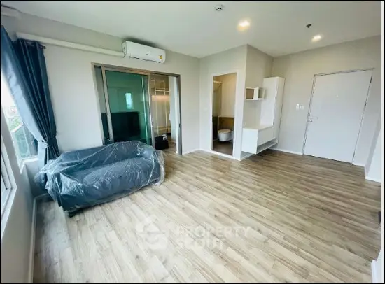 Spacious modern living room with wooden flooring and natural light