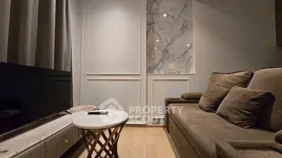 Elegant living room with plush sofa and marble accent wall, perfect for modern comfort and style.