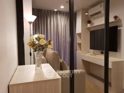 Modern living room with elegant decor and wall-mounted TV in a cozy apartment.