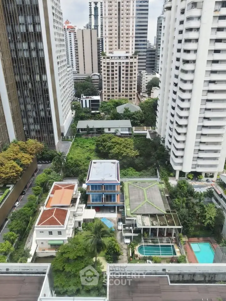 Stunning aerial view of urban high-rise buildings with lush greenery and swimming pools in a vibrant cityscape.