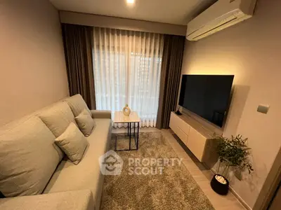 Cozy living room with modern decor, featuring a comfortable sofa, flat-screen TV, and elegant curtains.