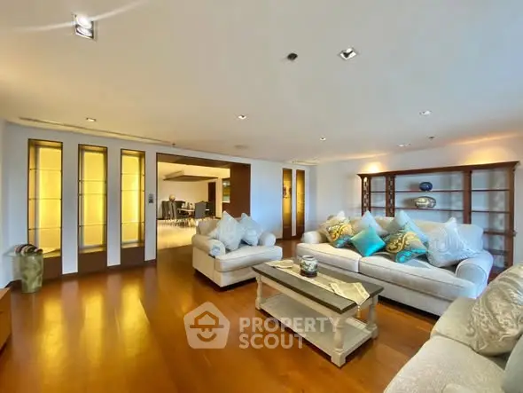 Spacious living room with elegant decor and wooden flooring in a modern apartment.