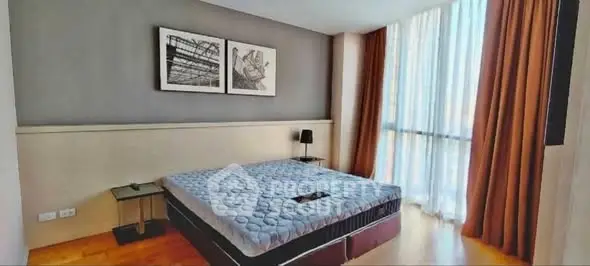 Spacious bedroom with modern decor and large window for natural light.