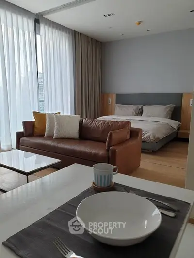 Modern studio apartment with cozy living area and stylish bedroom setup.