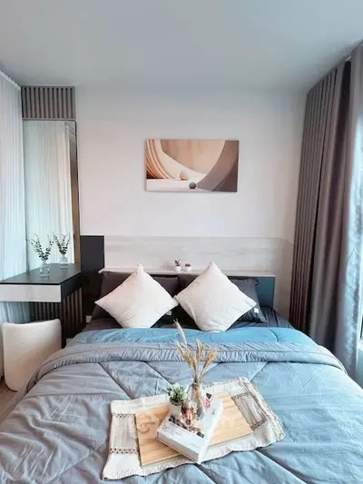 Modern bedroom with stylish decor and cozy bedding in a bright apartment.
