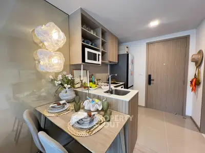 Modern kitchen with dining area, featuring sleek cabinetry and contemporary decor.