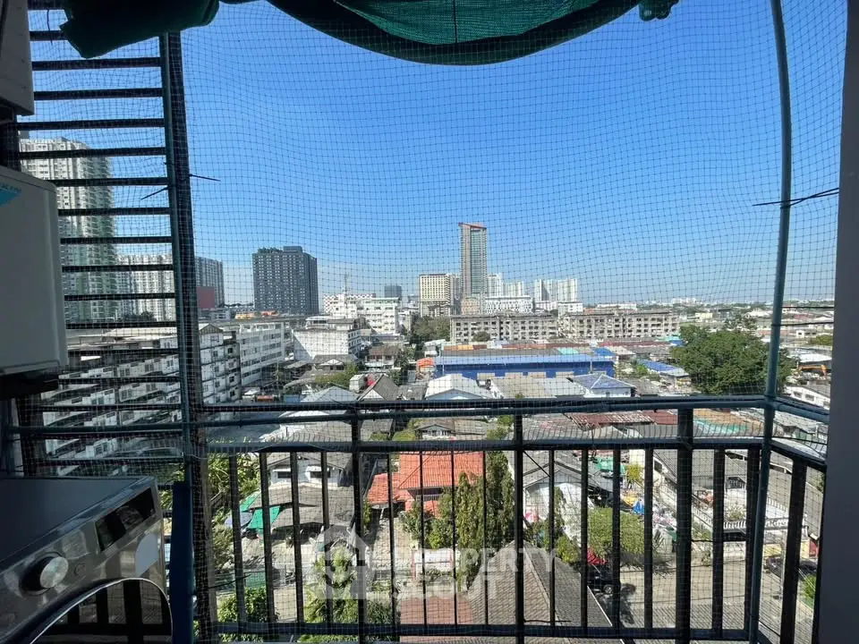 Stunning cityscape view from a high-rise balcony with safety netting, showcasing urban living.