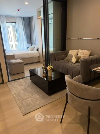 Modern living room with cozy seating and stylish decor adjacent to a bedroom.