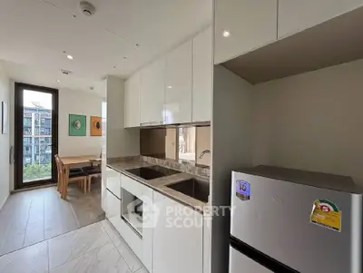 Modern kitchen with sleek cabinetry and dining area in a bright apartment