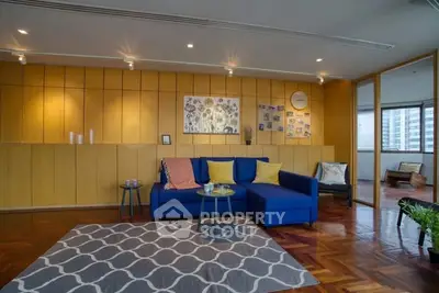 Spacious living room with modern decor and large windows offering city views.