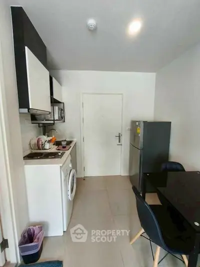 Compact kitchen with modern appliances and dining area in cozy apartment