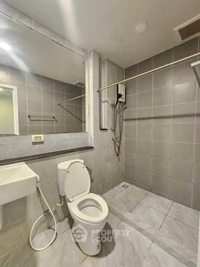 Modern bathroom with sleek gray tiles and open shower design