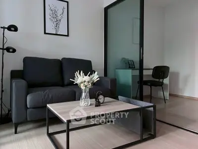 Modern living room with sleek black sofa, stylish coffee table, and elegant decor in a contemporary apartment.