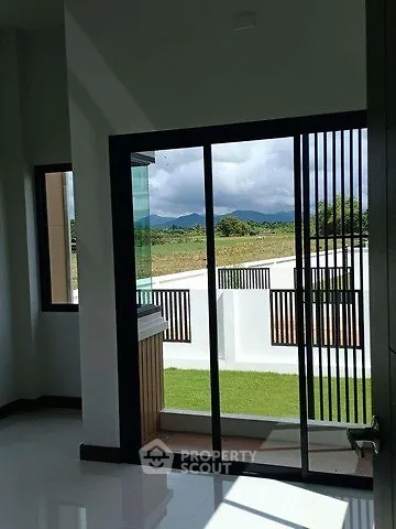 Modern interior with sliding glass doors opening to a scenic view of lush greenery and mountains.