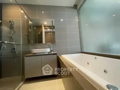 Modern bathroom with sleek design featuring a glass shower and luxurious bathtub.