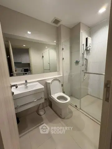 Modern bathroom with glass shower and sleek fixtures in a contemporary apartment.