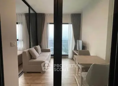 Modern living room with balcony view, featuring sleek furniture and natural light.