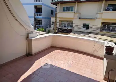 Spacious balcony with tiled flooring and neighborhood view