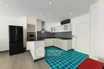 Modern kitchen with sleek black appliances and vibrant blue tile flooring