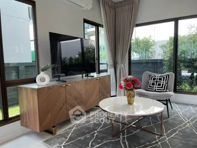 Modern living room with stylish furniture and large windows offering natural light.