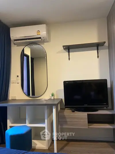 Modern bedroom with TV, mirror, and air conditioning unit.