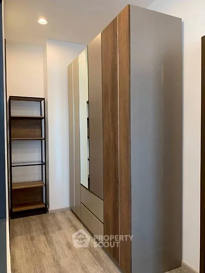 Modern storage space with sleek wooden cabinets and open shelving.