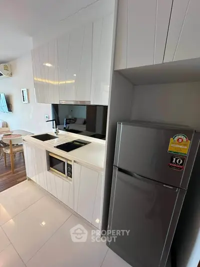 Modern kitchen with sleek cabinetry and stainless steel fridge in a stylish apartment.