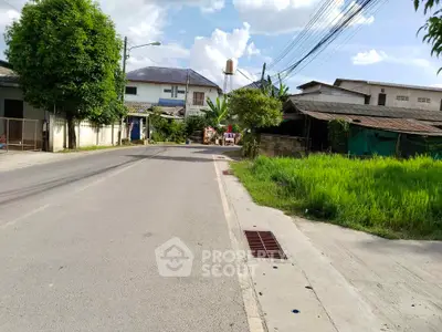 Charming suburban street view with lush greenery and residential homes, perfect for peaceful living.
