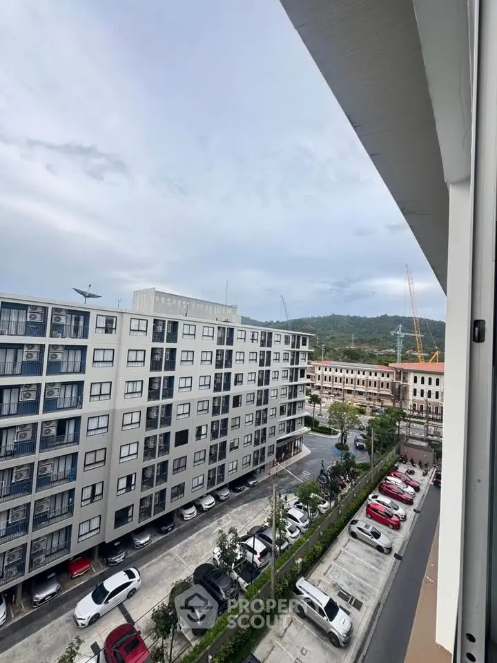 Modern apartment building with parking and scenic mountain view.