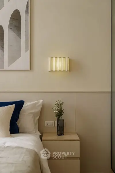 Elegant bedroom with modern wall art and cozy lighting, perfect for relaxation.