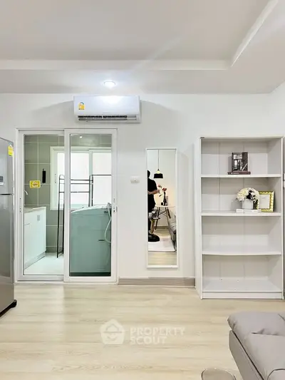 Modern living room with sleek design, featuring air conditioning and stylish shelving, perfect for urban living.